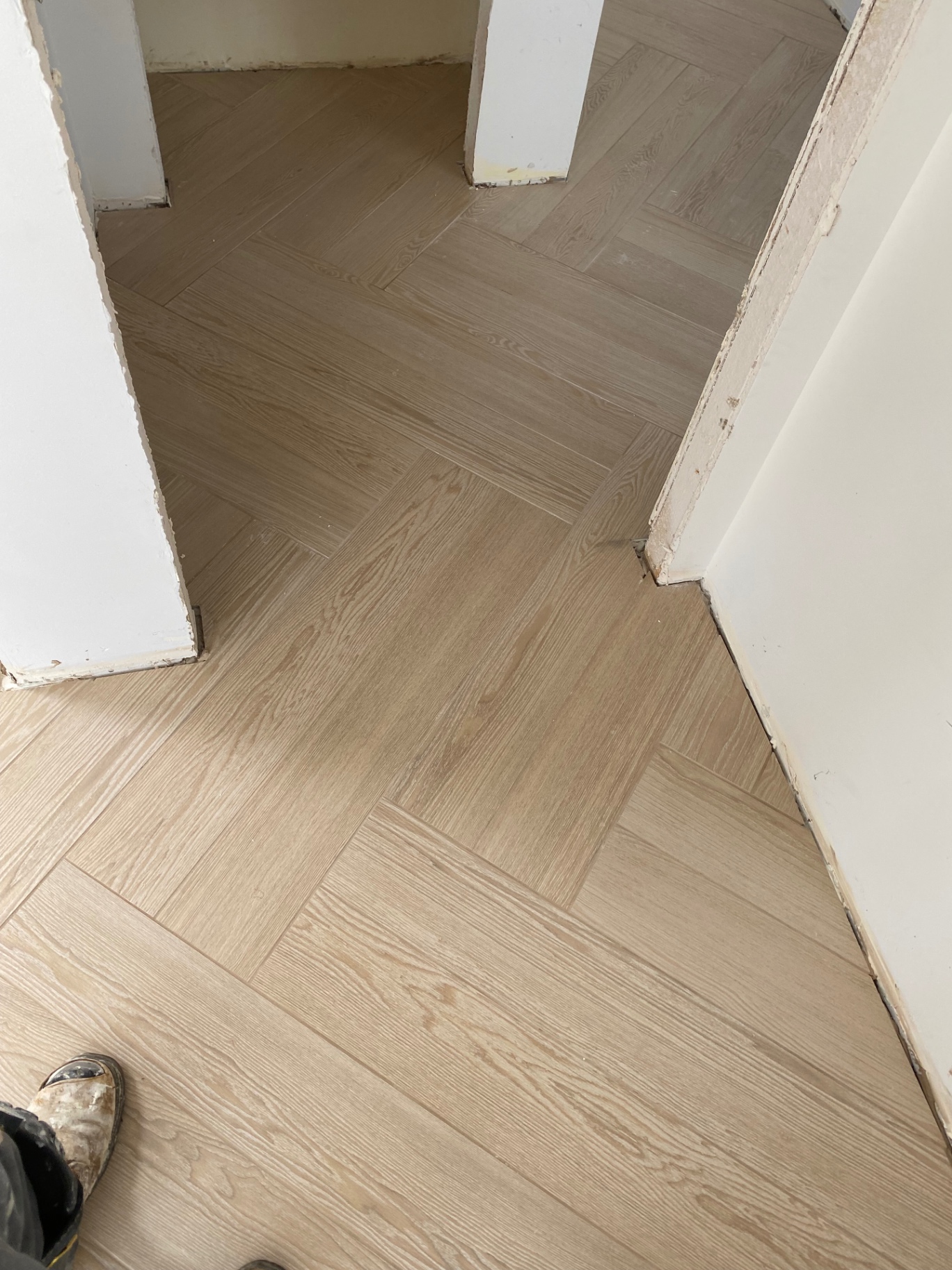 Herringbone wood-look porcelain tile in hallway with transitions to multiple rooms