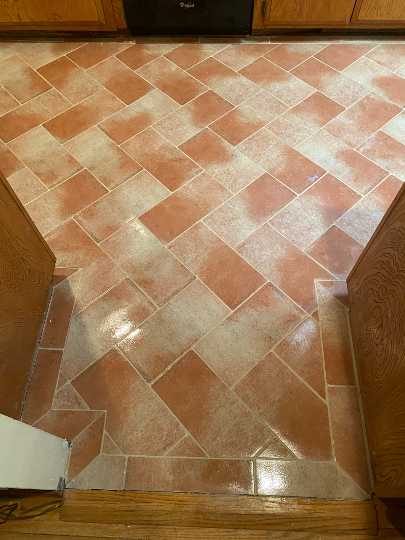 Terracotta herringbone kitchen floor with custom border at cabinet base