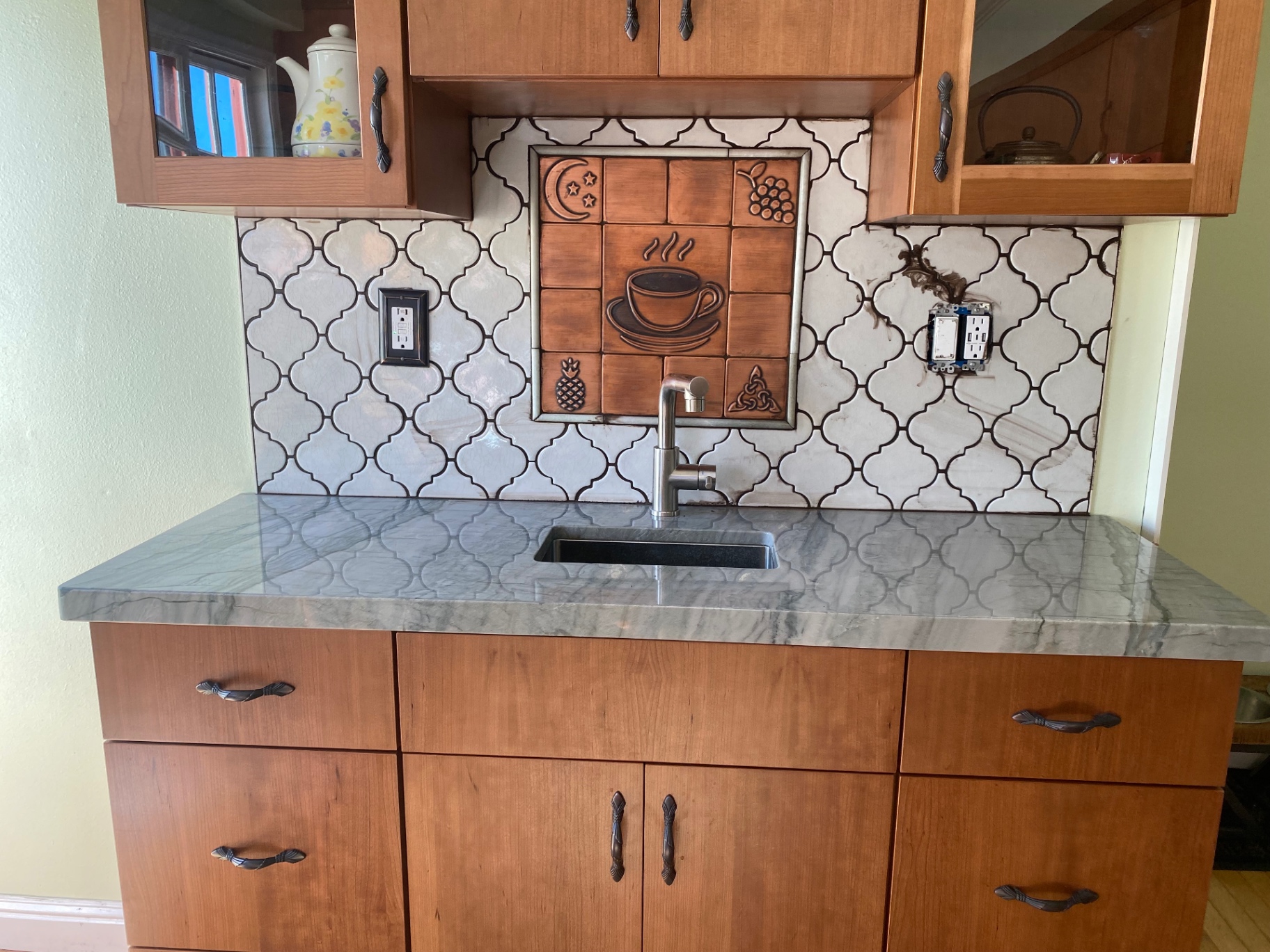 Arabesque tile coffee bar backsplash with copper accent mural