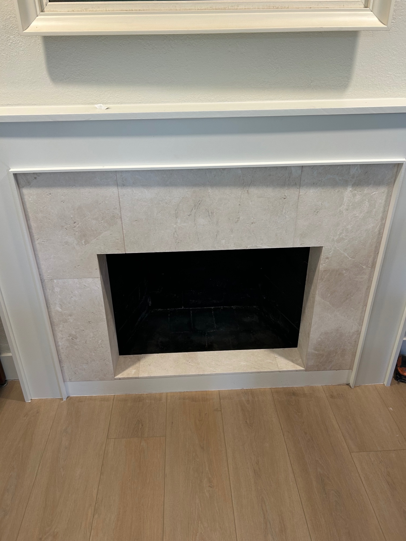 Cream marble-look tile fireplace surround with white mantel