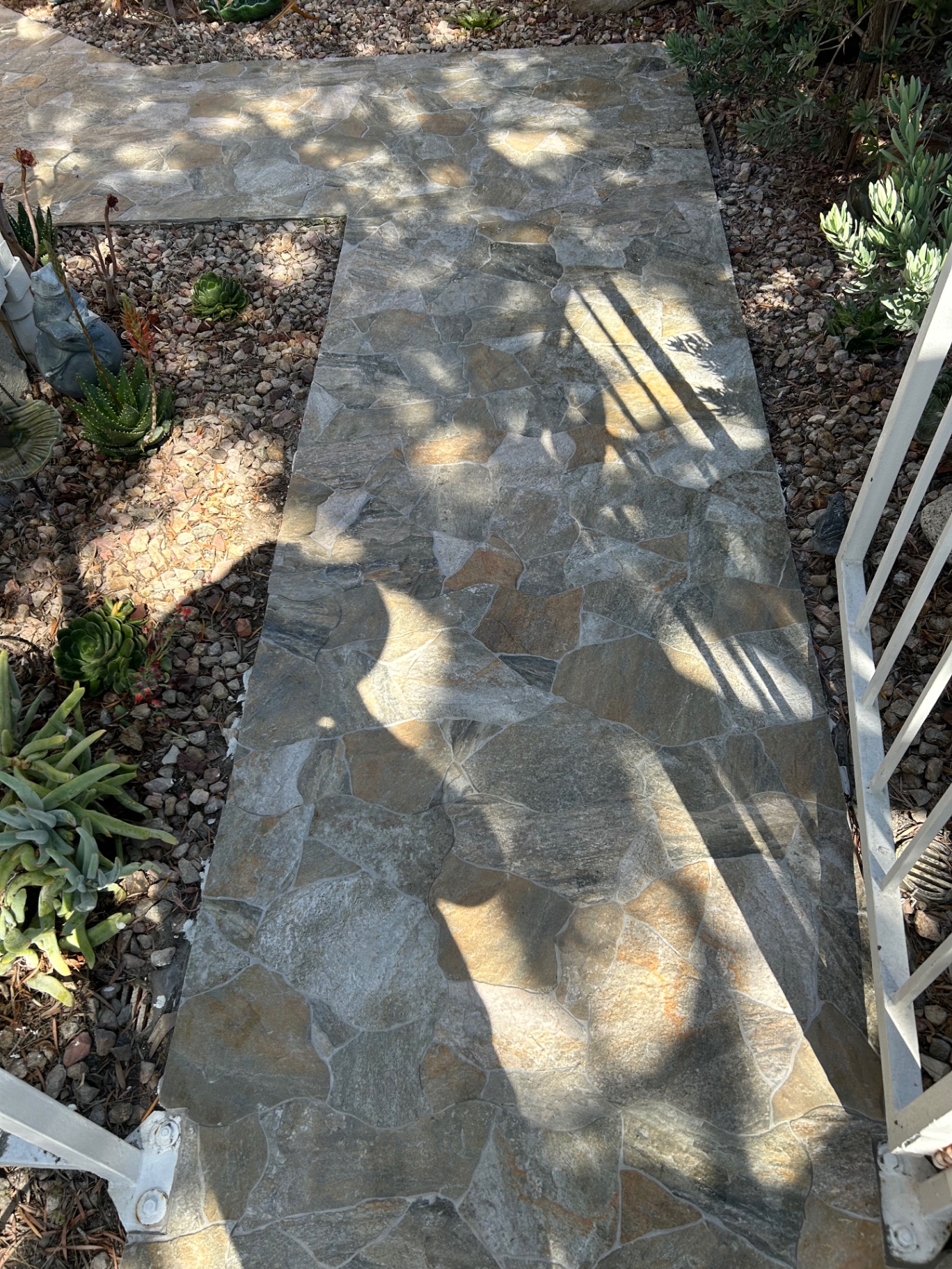 Flagstone-look porcelain path through succulent garden with gravel borders