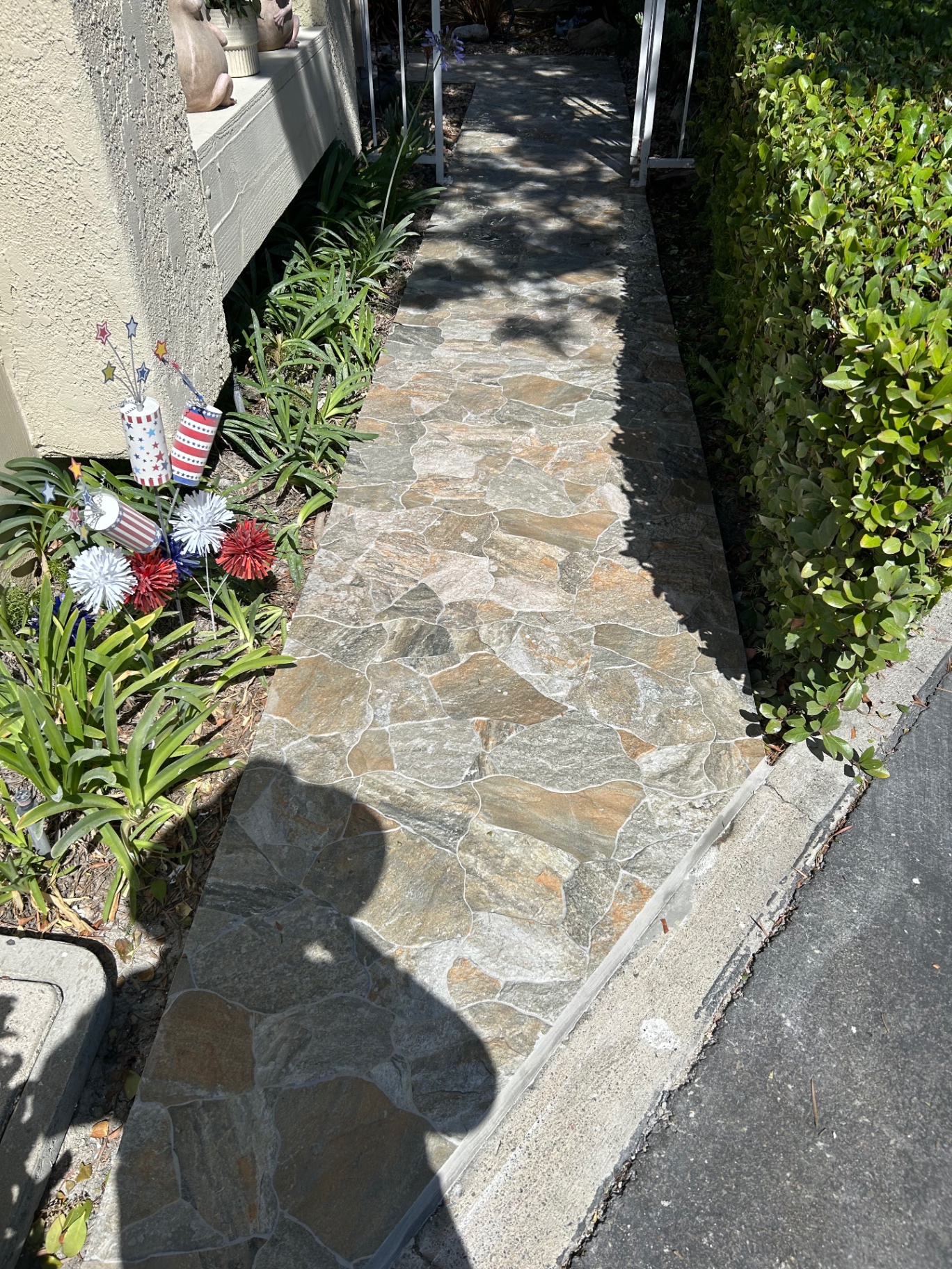 Porcelain flagstone-look walkway leading to front entry through landscaped yard