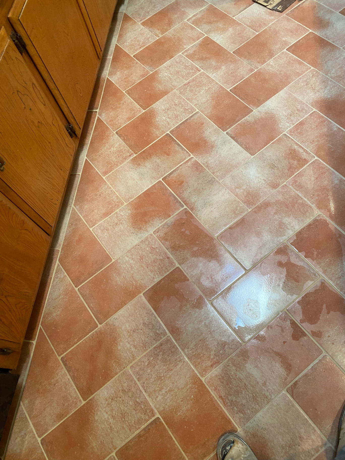 Classic terracotta-look tile floor laid in herringbone pattern in kitchen