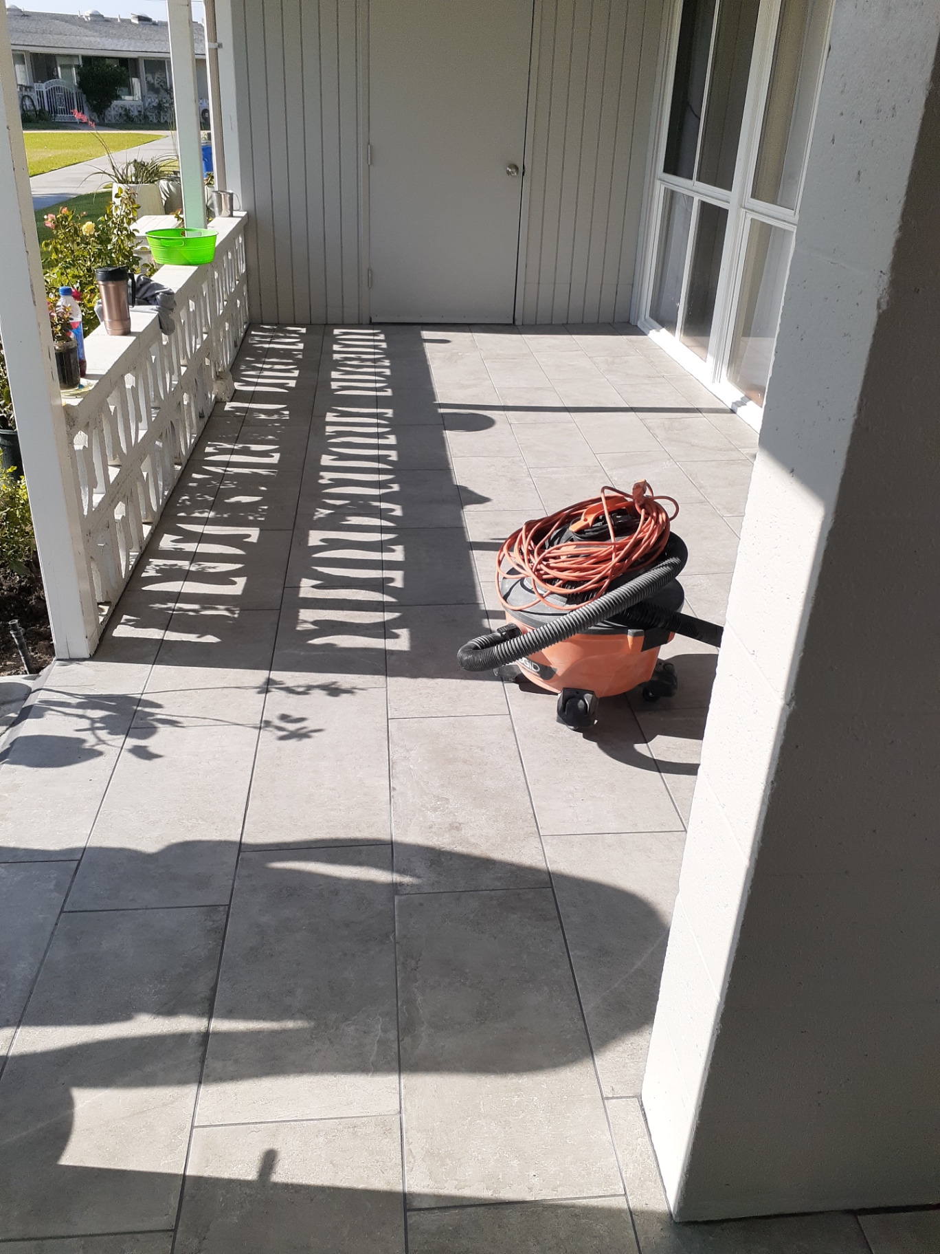 Covered front porch finished with large-format gray outdoor tile