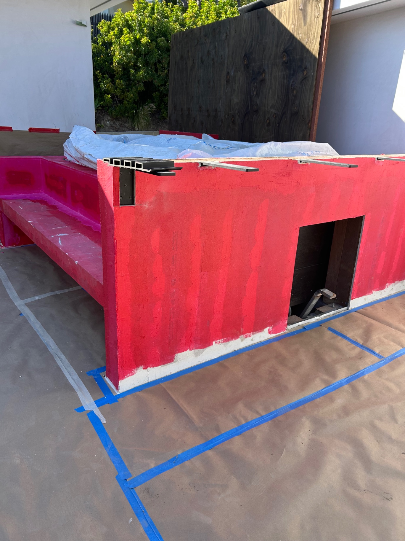 Red waterproofing membrane on hot tub surround and bench