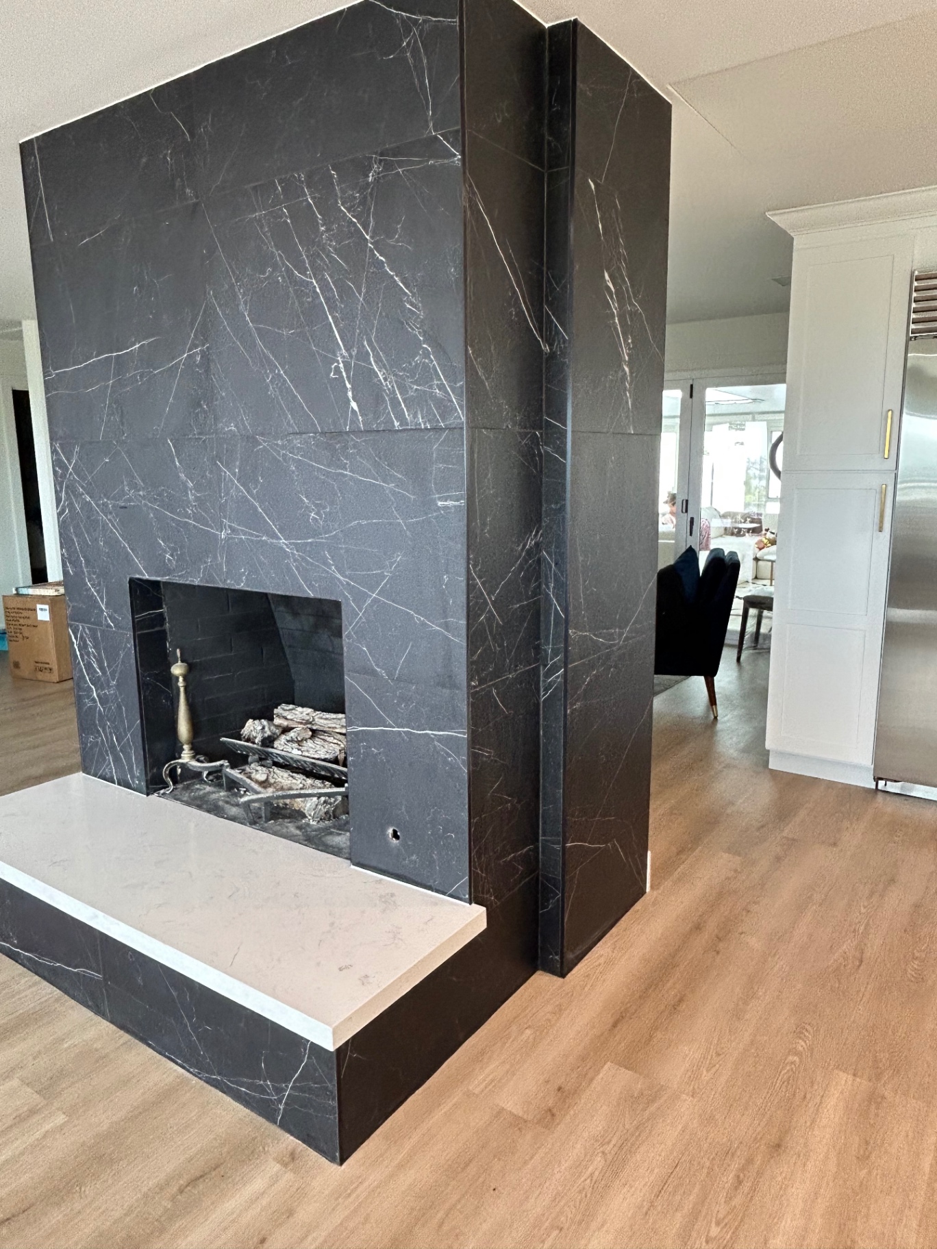Modern fireplace with black marble-look porcelain surround and quartz hearth