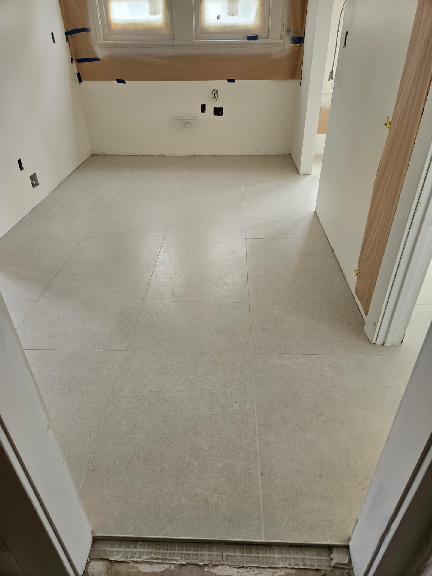 Limestone-look porcelain floor tile running through hallway and bathroom