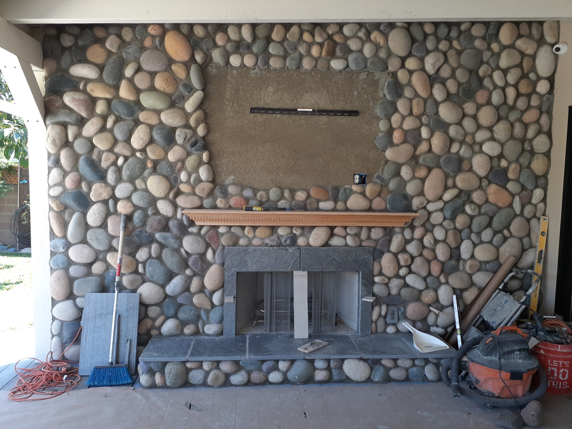 River rock fireplace wall with stone hearth and mantel