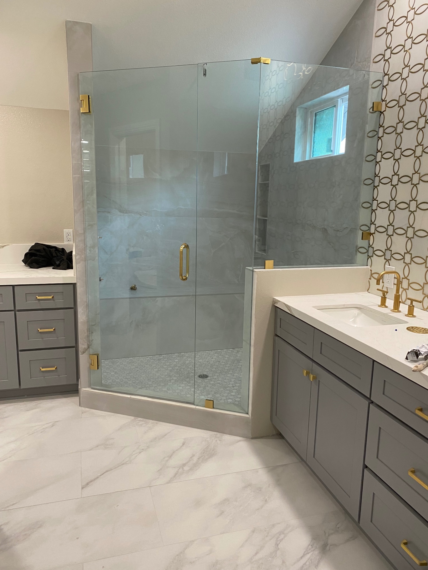 Master bath with onyx-look shower and gold geometric mosaic feature wall