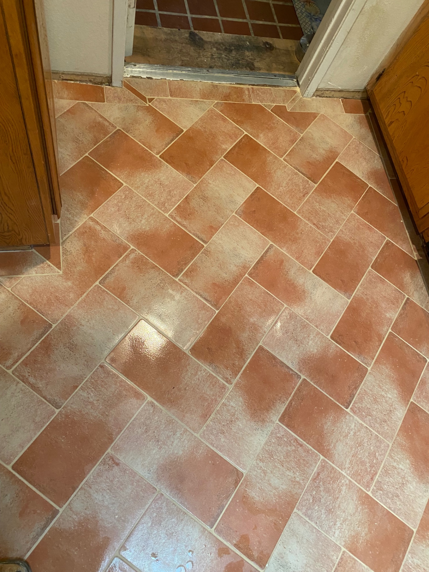 Terracotta herringbone tile at kitchen door threshold and entry