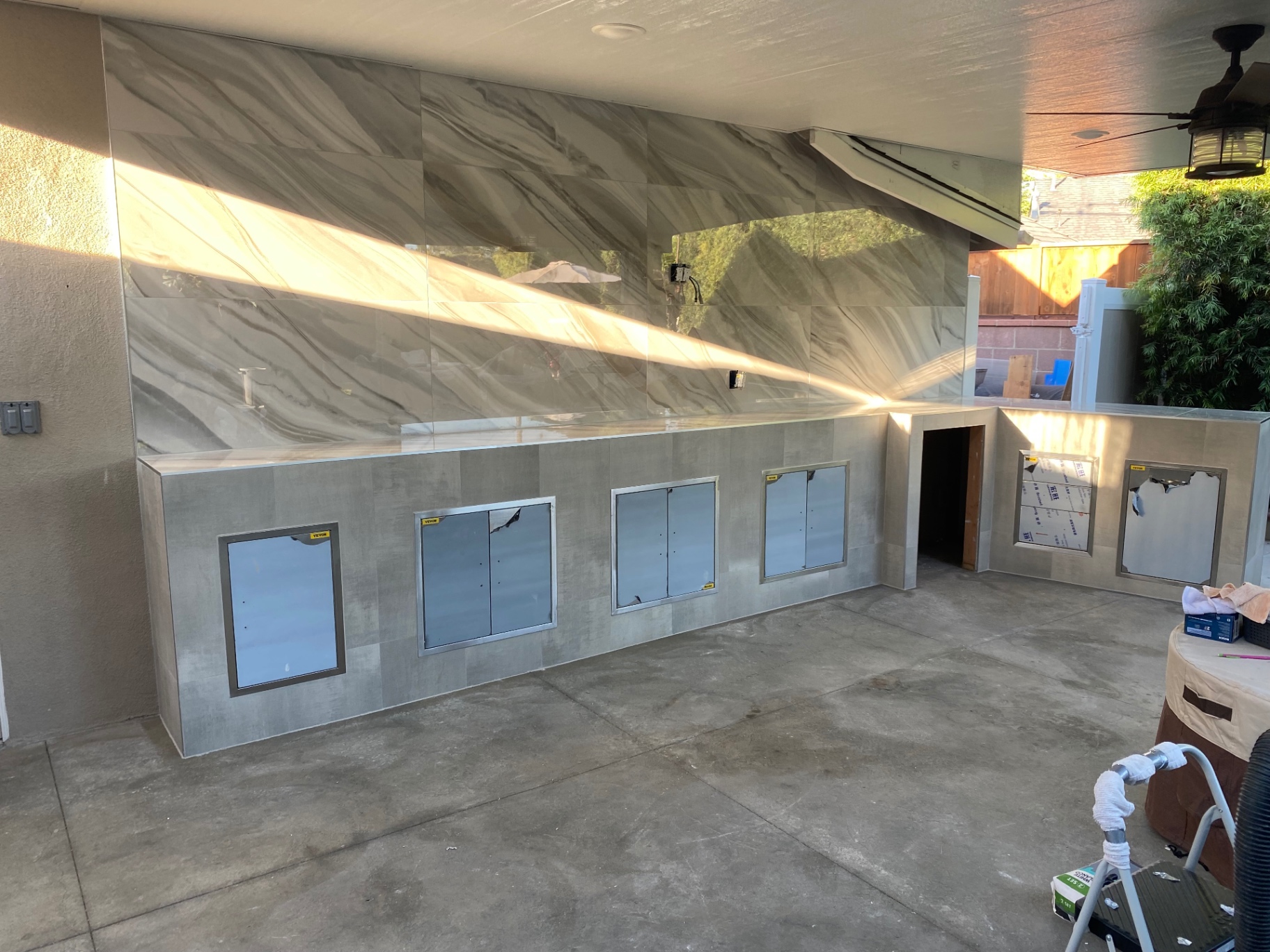 Outdoor kitchen with large-format marble-look porcelain feature wall
