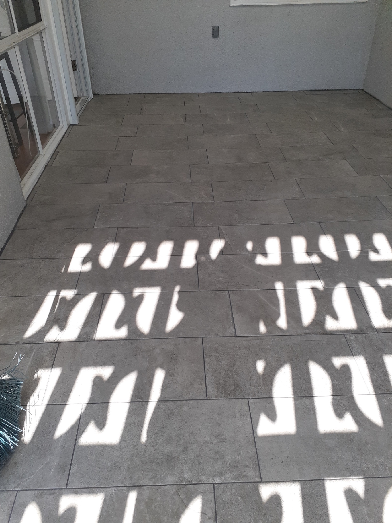 Outdoor patio installation with large-format gray porcelain tile
