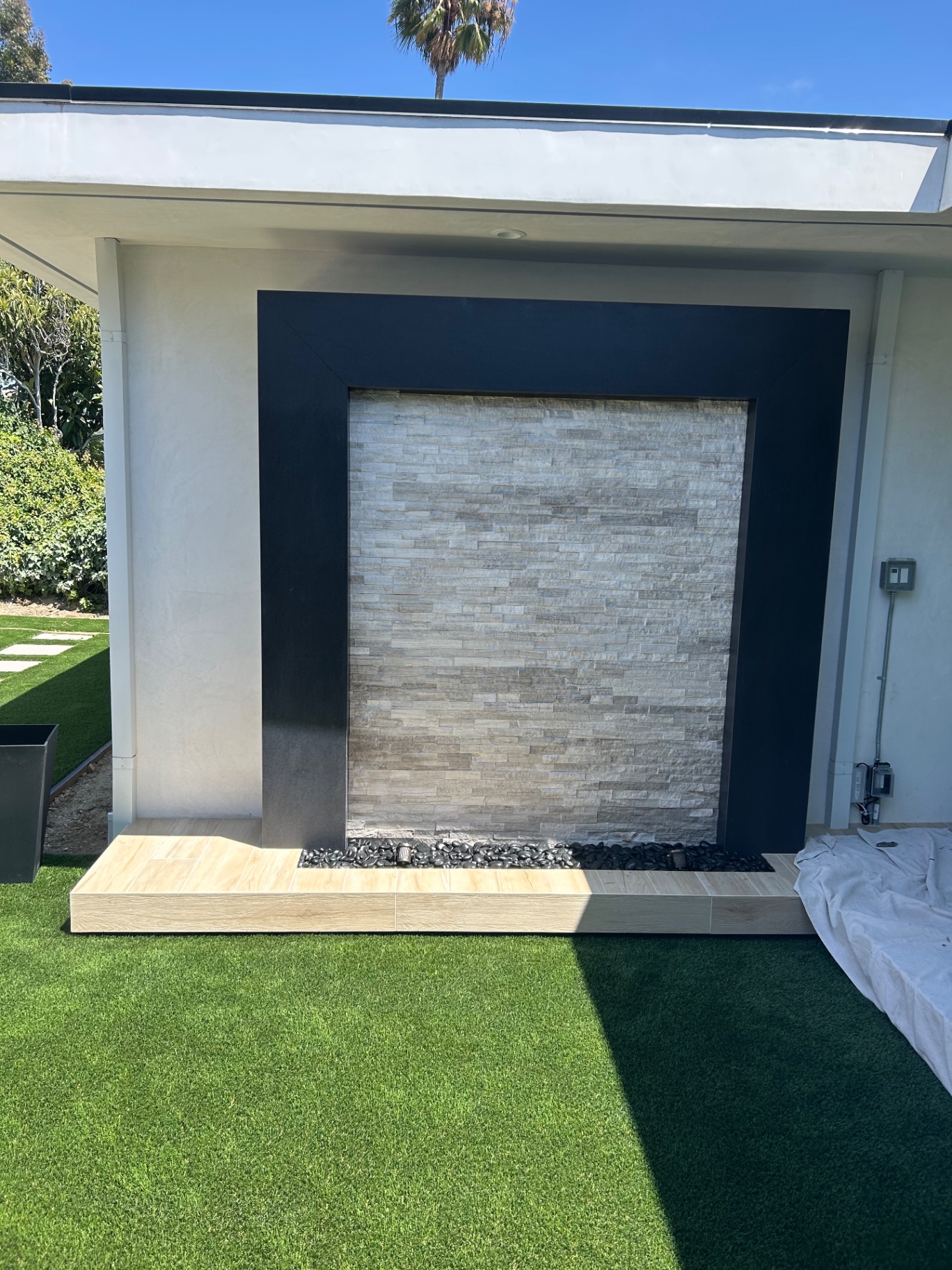 Stacked stone water feature wall set in dark frame