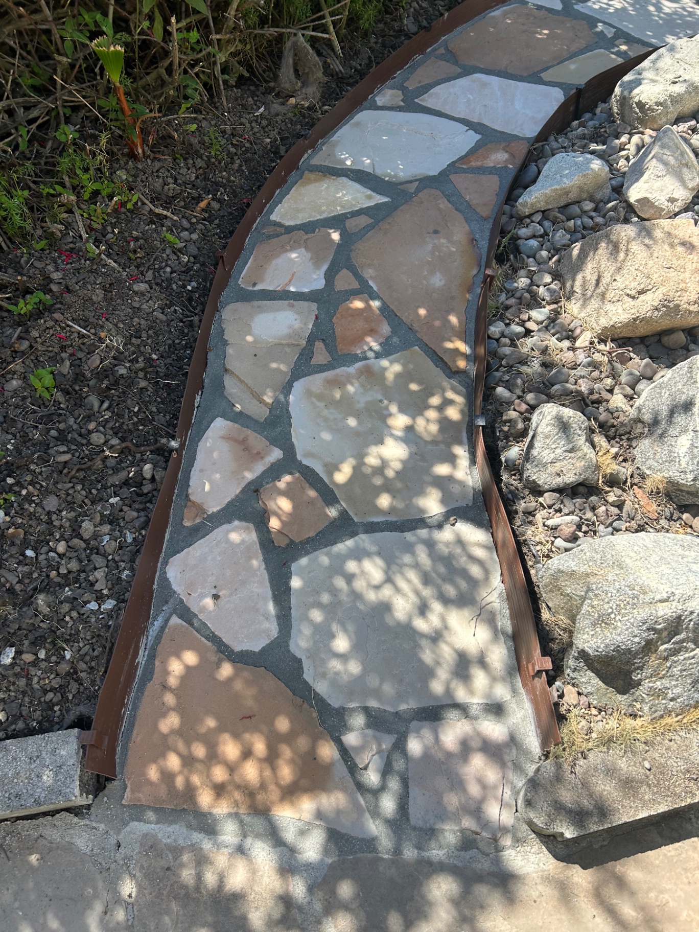 Detail of curved flagstone path with dark grout