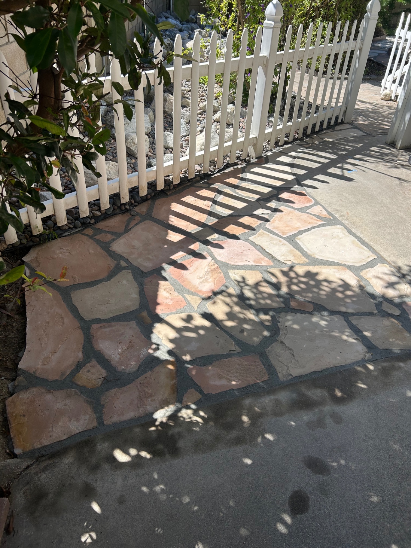 Flagstone patio area along white picket fence