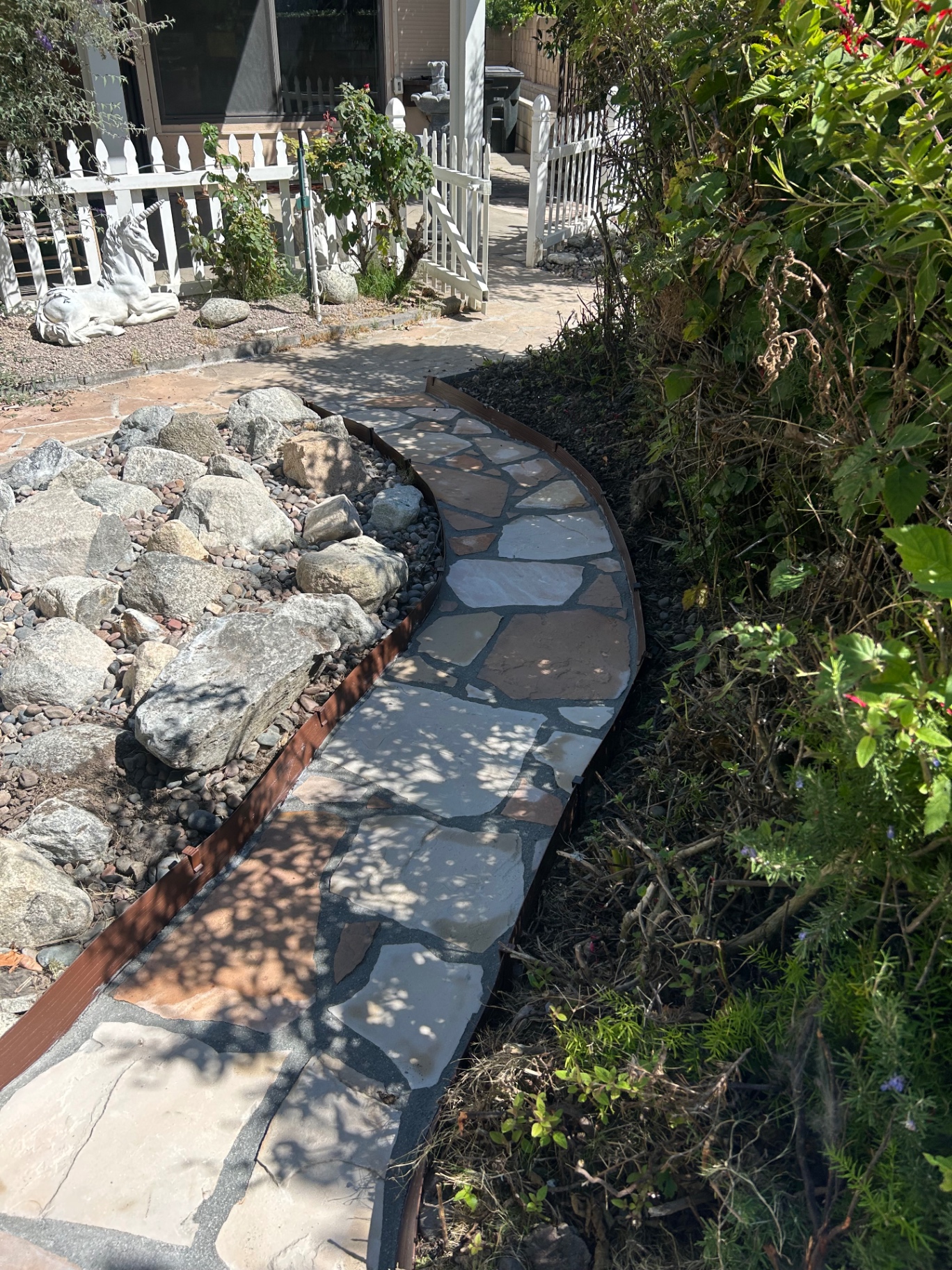 Curved flagstone walkway through landscaped front yard