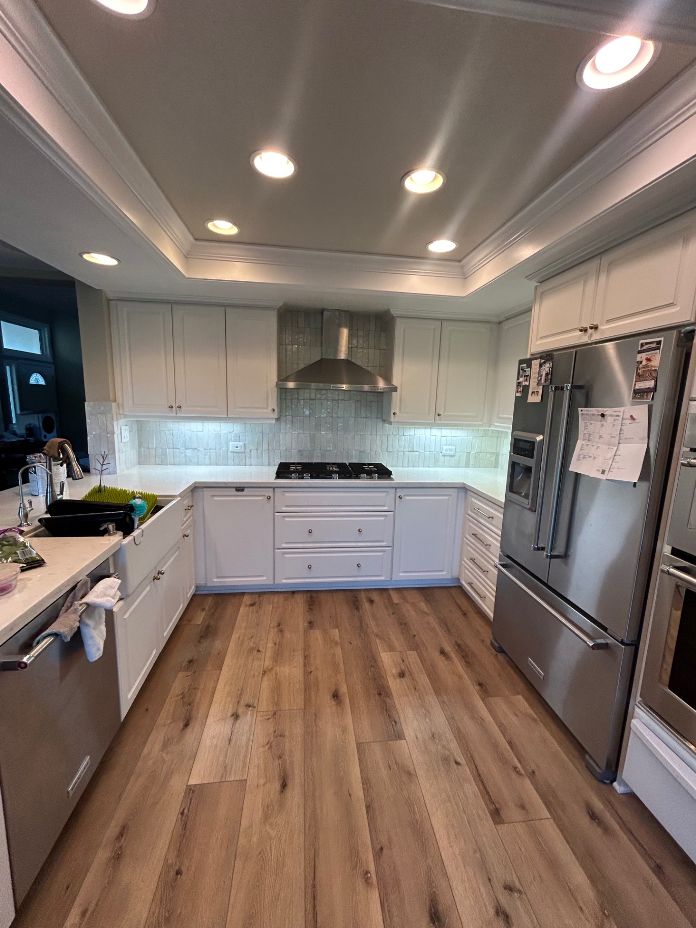 White kitchen with handmade zellige backsplash and stainless hood