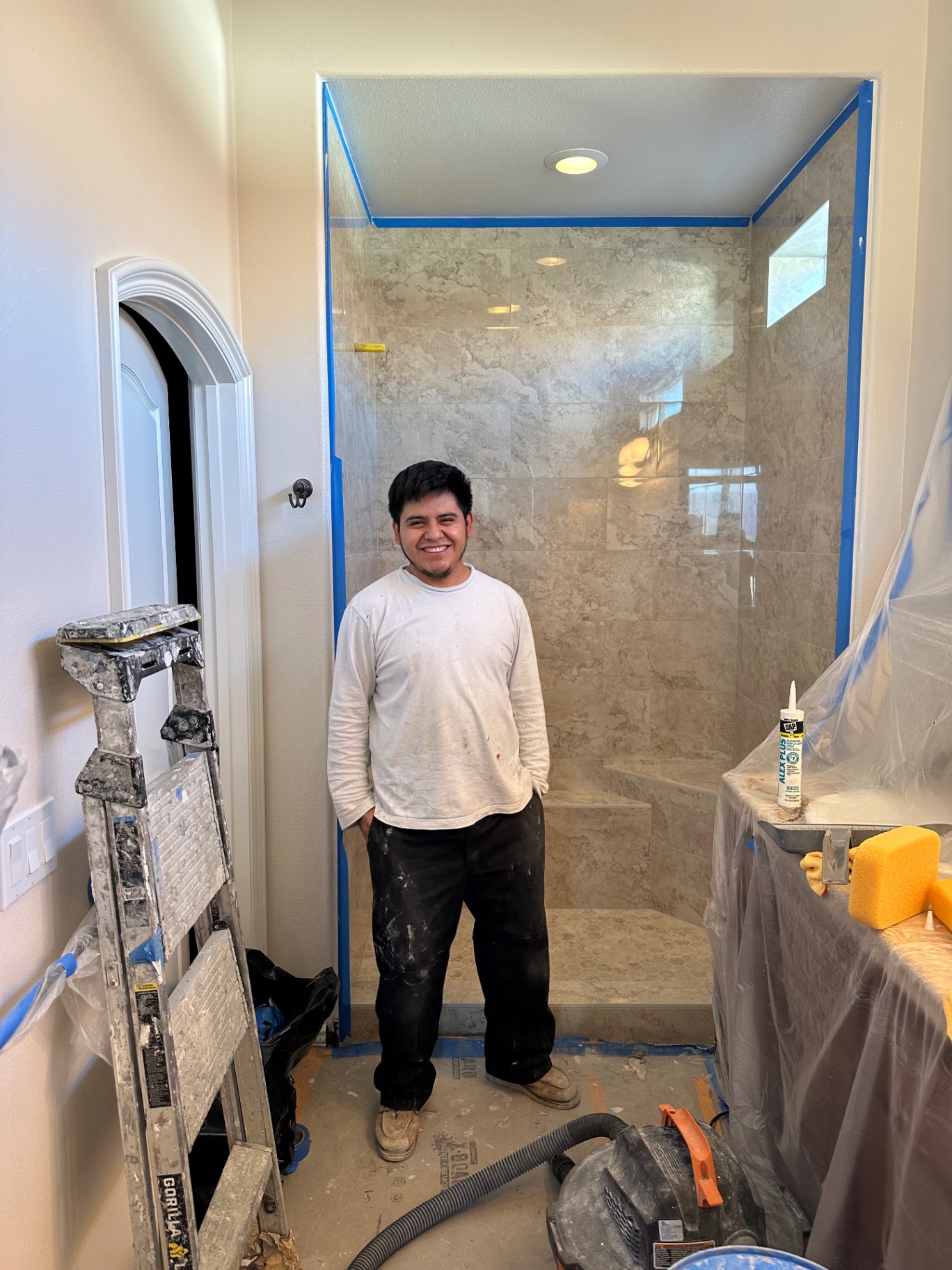 Prime Tile Work installer in front of finished marble shower