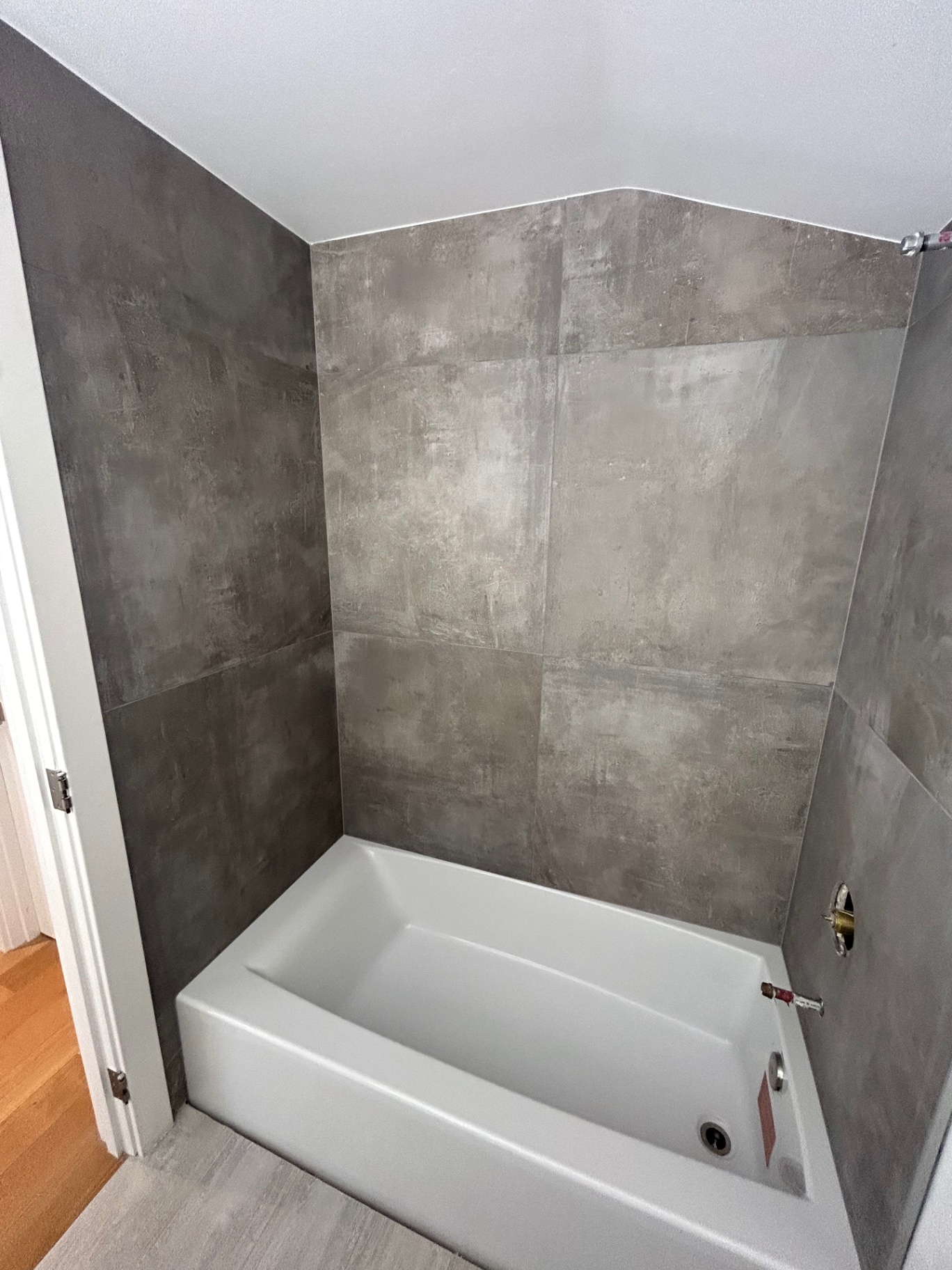 Tub surround in large-format concrete-look porcelain tile