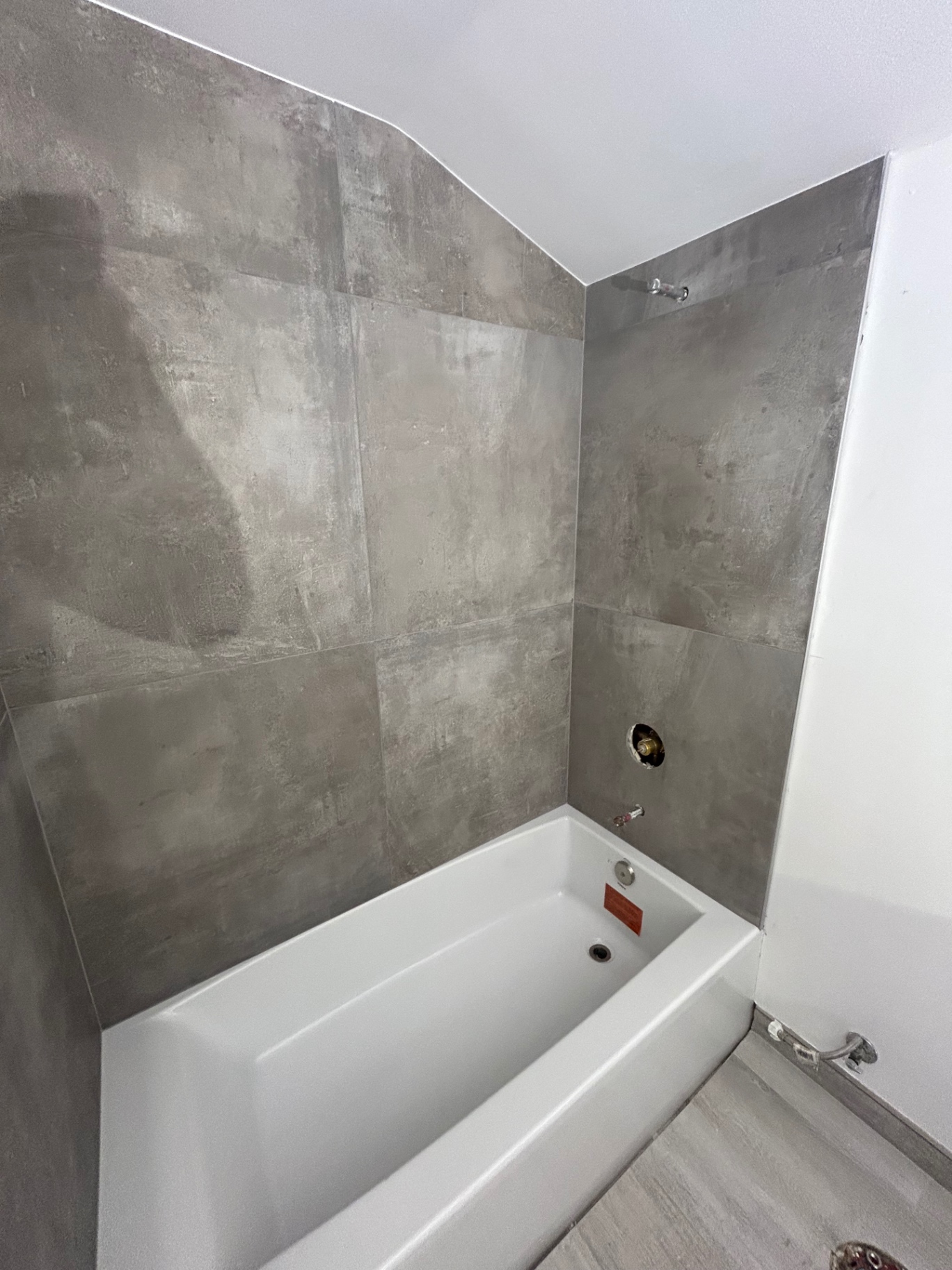 Detail of concrete-look tile tub surround with niche